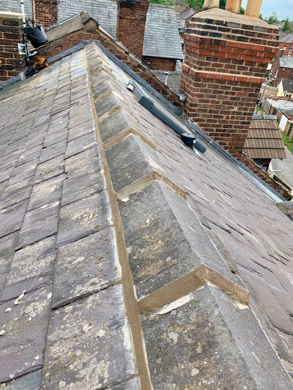 a picture of the top of a pitched slate roof